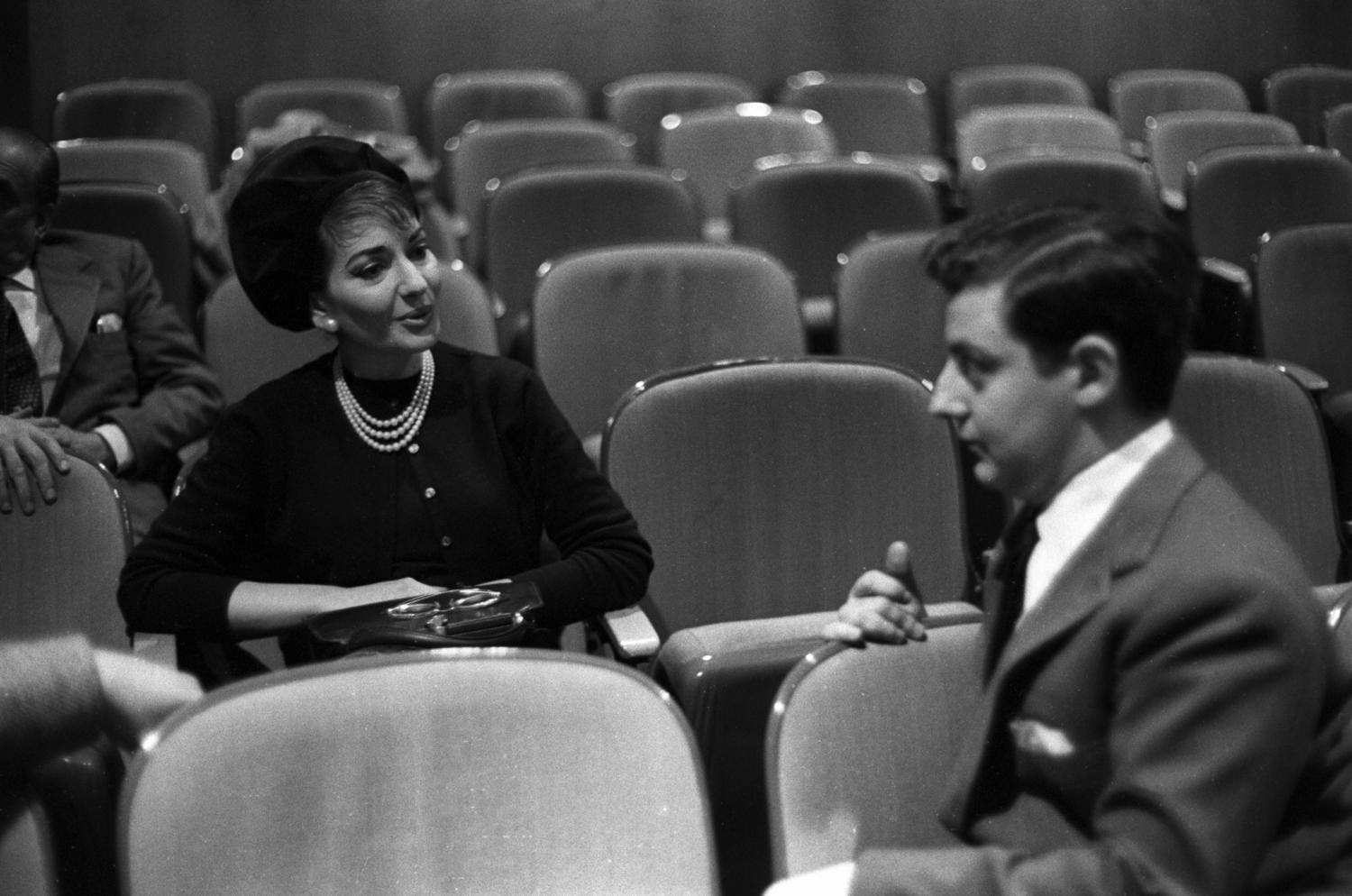 Maria Callas and Nicola Rescigno sitting in auditorium chairs