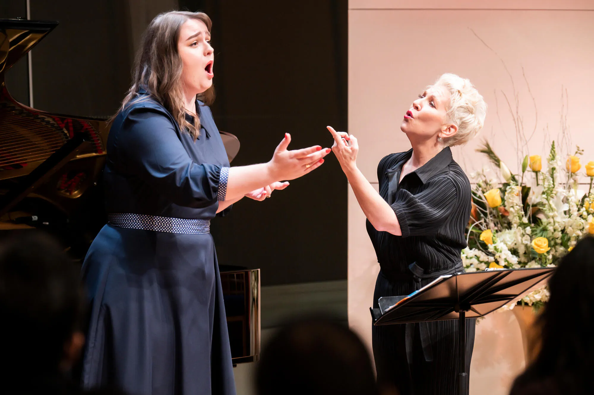 Joyce DiDonato coaches a woman singing in a blue dress, hands outstretched