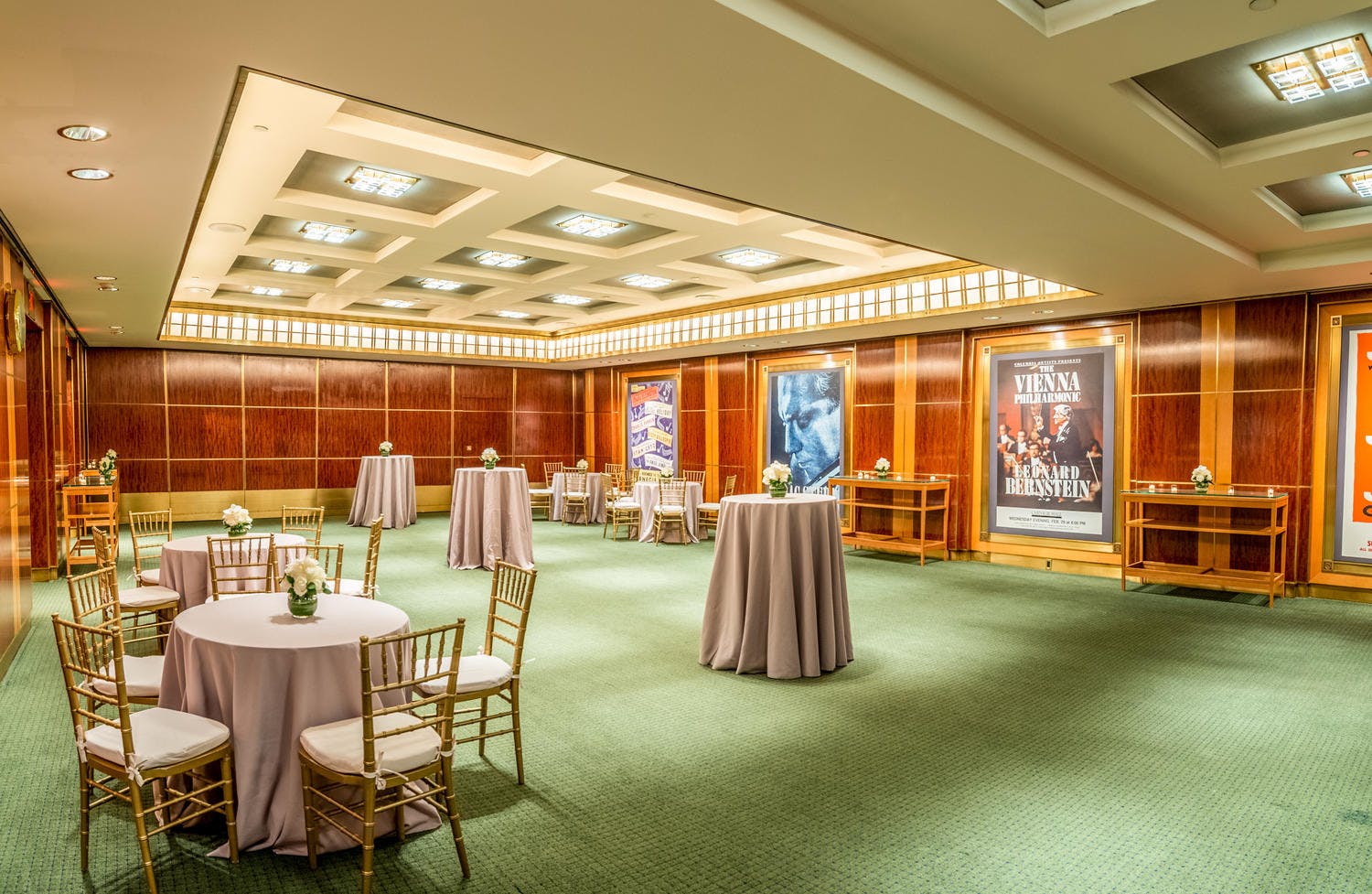 Rohatyn Room brightly lit and set with cocktail tables and florals for a reception