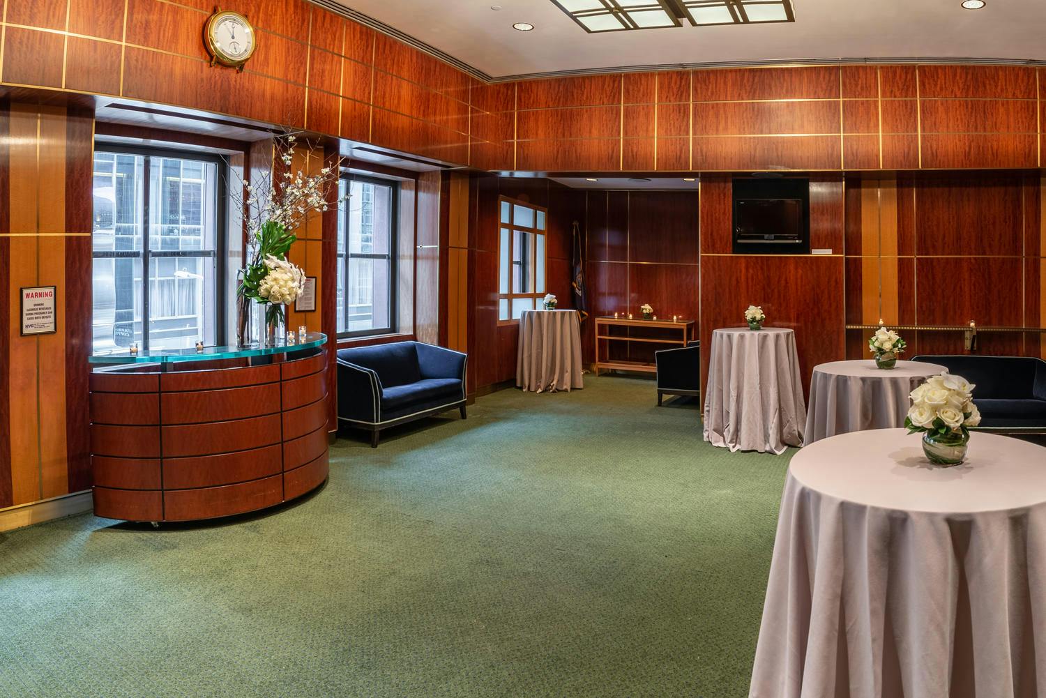A bar, soft seating, and high cocktail tables with florals set in the Shorin Club Room