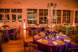 Violet and apple-green dinner tables in the Weill Terrace Room with candelabra and gold touches