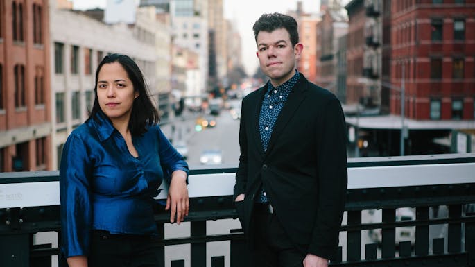On the High Line, a woman wears a blue blouse and a man wears a blazer and blue shirt.