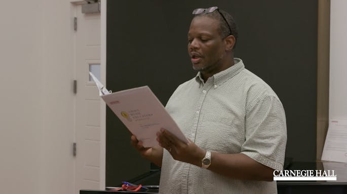 A man reads from a binder