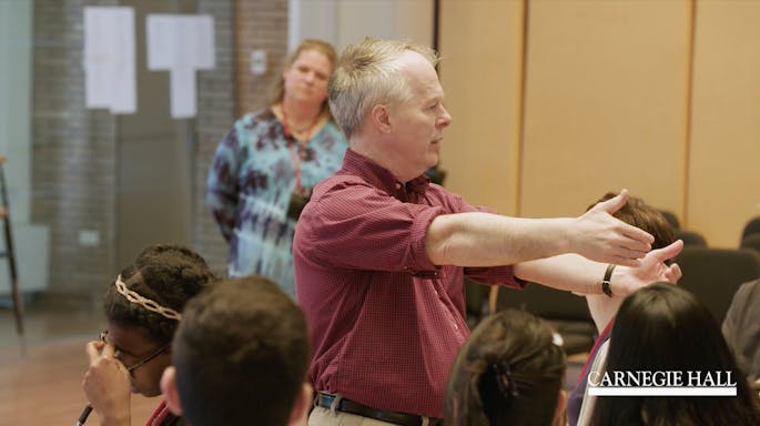A presenter speaks before a class of educators