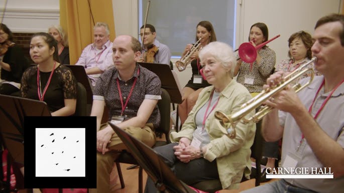 A group of teachers listen as brass musicians perform