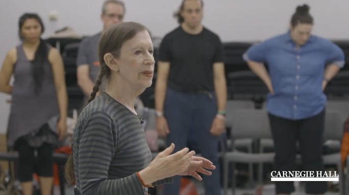 A woman speaks before a group of teachers in a workshop