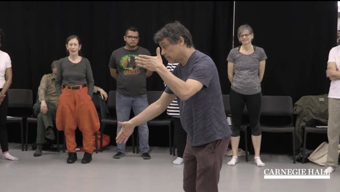 A presenter displays movements for a group of teachers