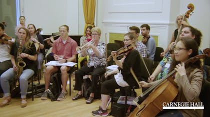An orchestra of teachers performs in a classroom