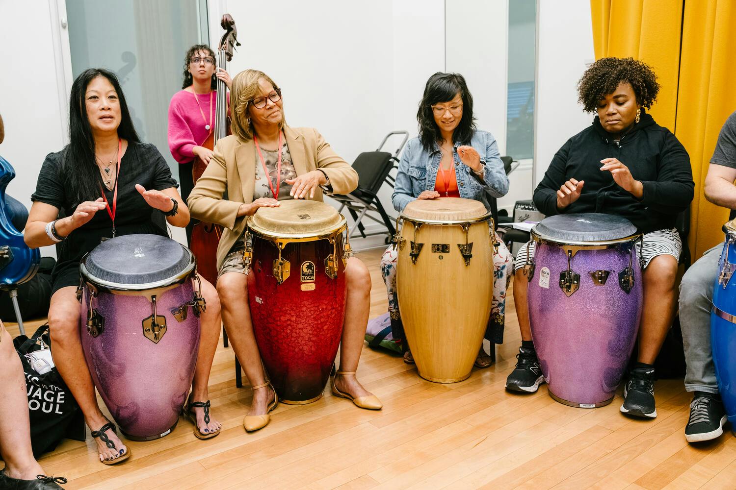 Four young women play conga drums