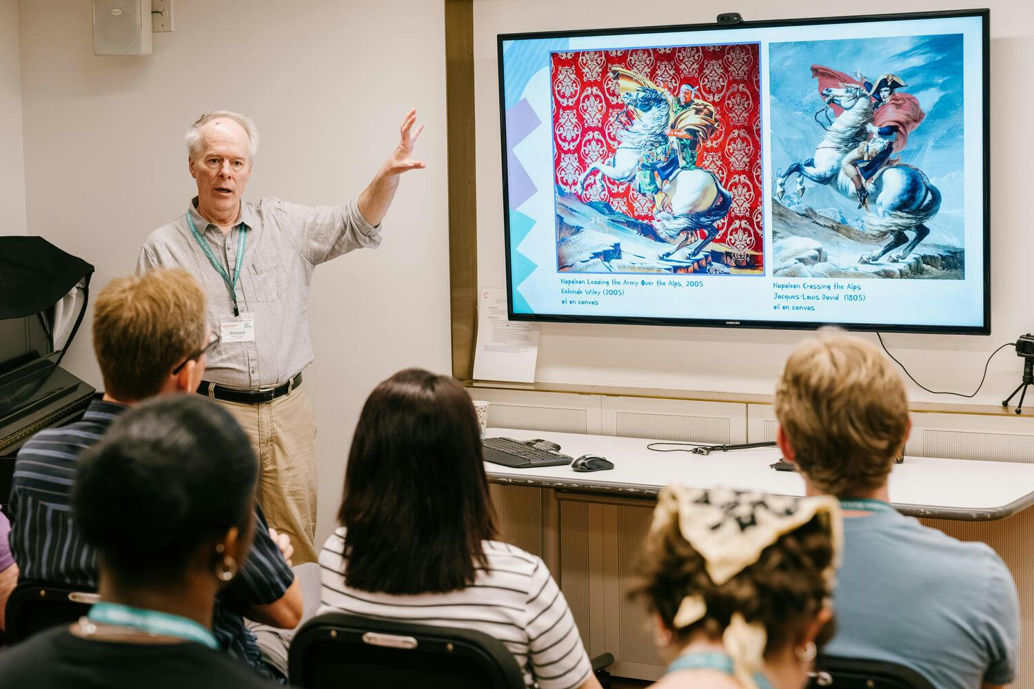 A man presents illustrations on a screen as five people look on