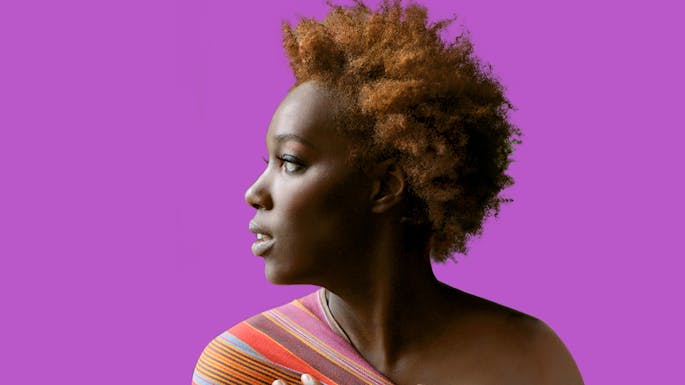 Imani Uzuri against a purple background