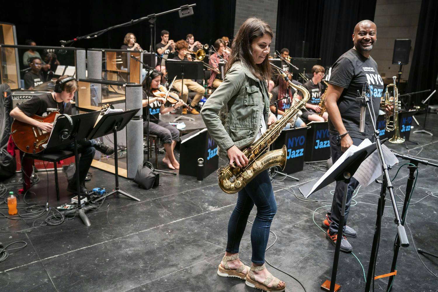 Sean Jones watches smiling as Melissa Aldana plays sax in the recording studio