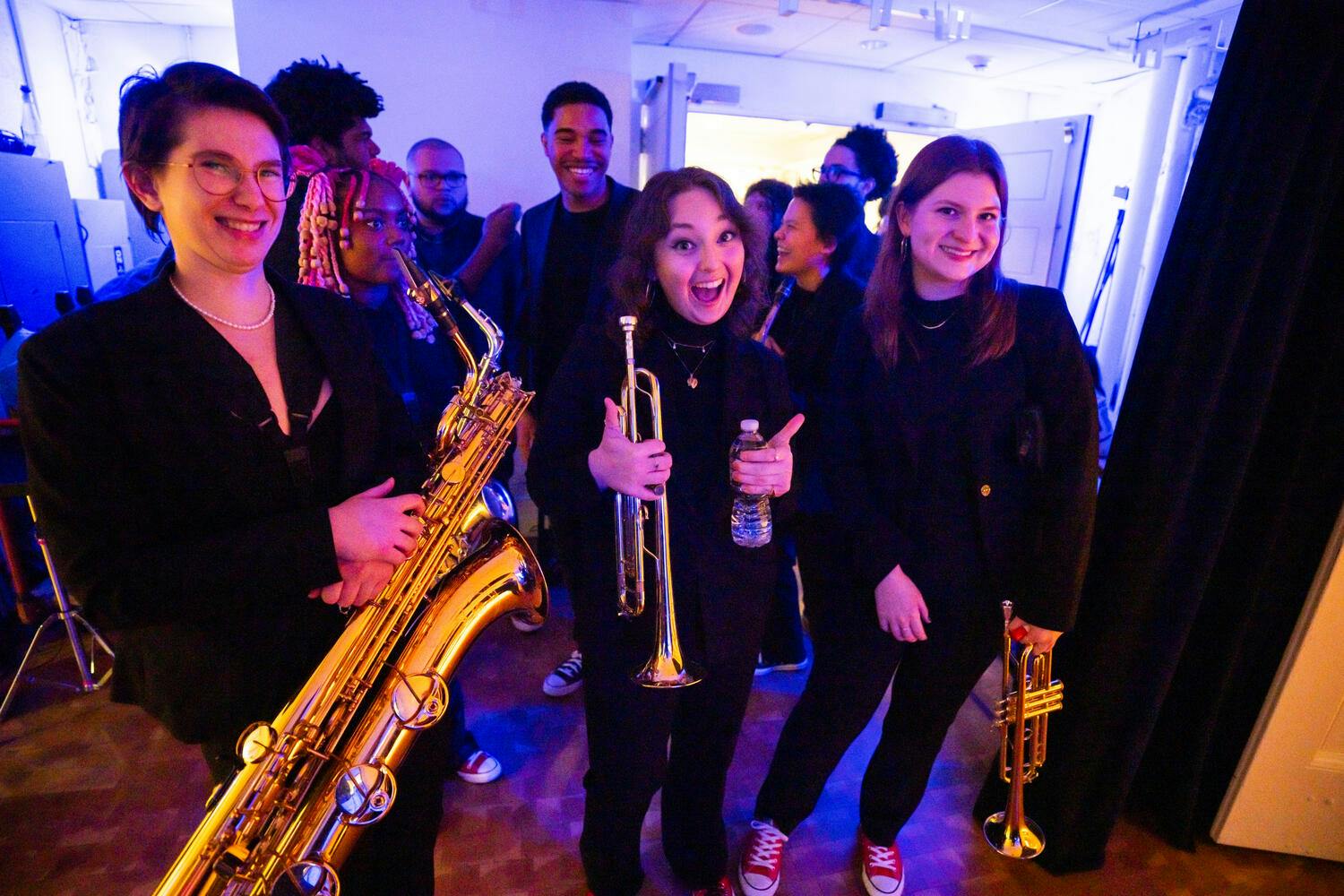 Three female NYO Jazz musicians smiling backstage
