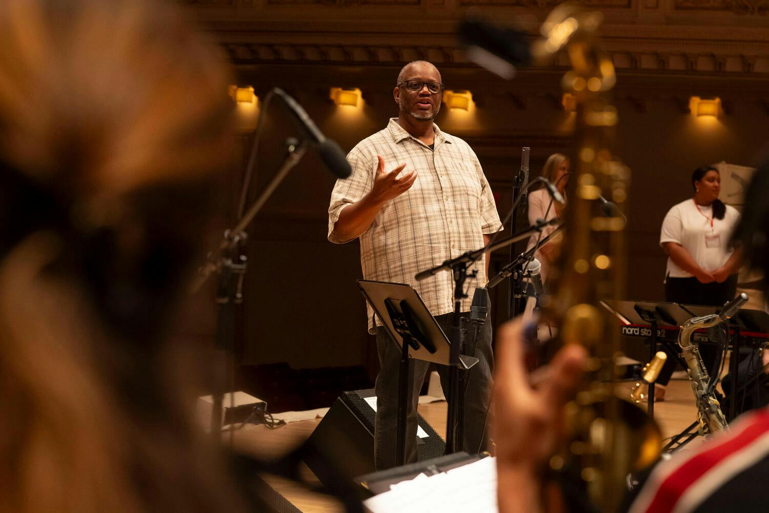 A man speaks with the band on stage