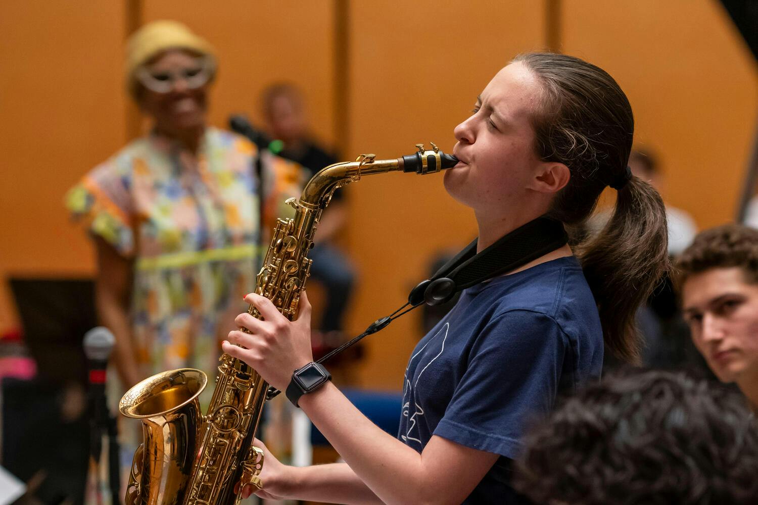 NYO Jazz female saxophonist performs, Dee Dee Bridgewater smiling in the background