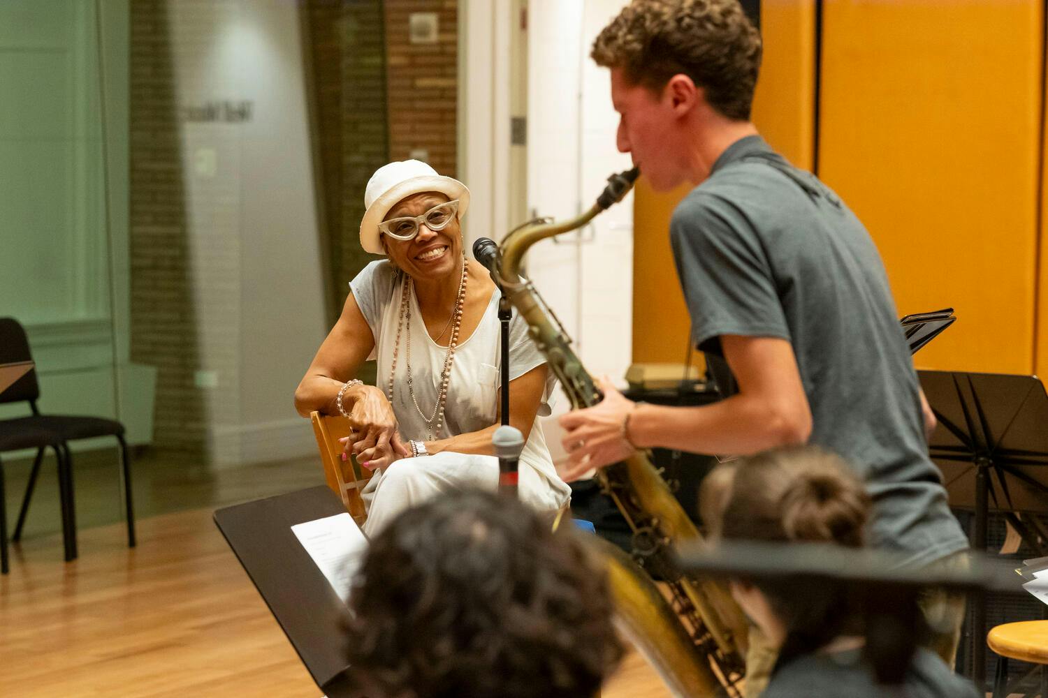 NYO Jazz male saxophonist performs as a smiling Dee Dee Bridgewater watches