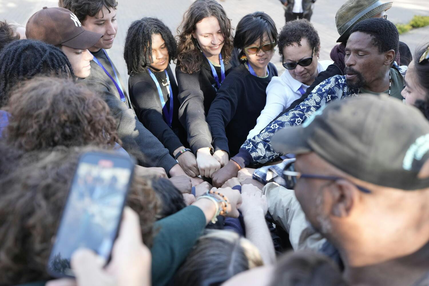 Musicians of NYO Jazz put their hands together in a circle