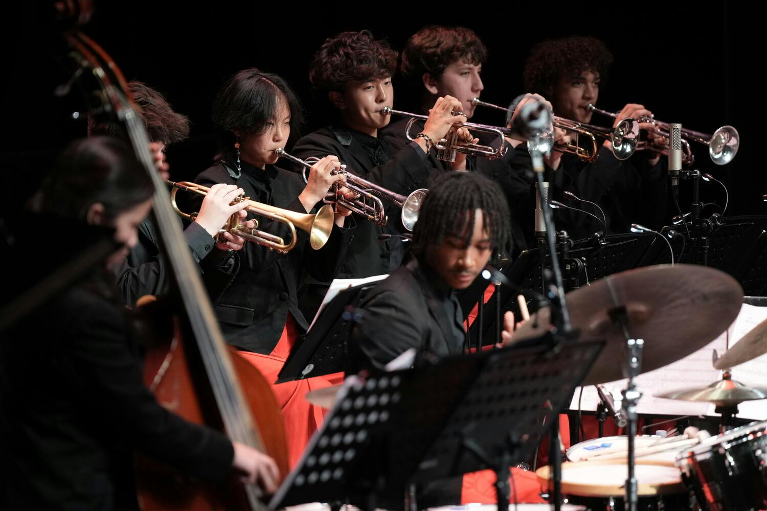Trumpeters, a bass player and drummer perform together on stage