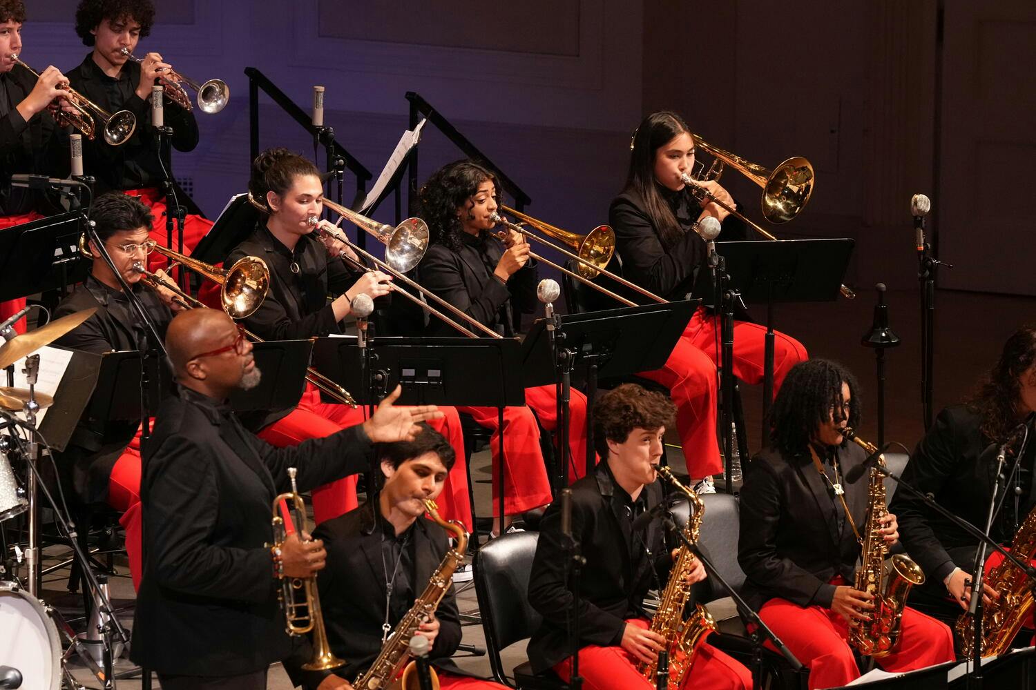 The NYO Jazz Band performs on stage as Sean Jones stands by with trumpet