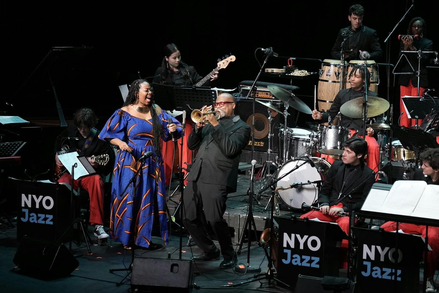 The NYO Jazz Band performs on stage as Sean Jones plays trumpet and Alicia Olatuja sings