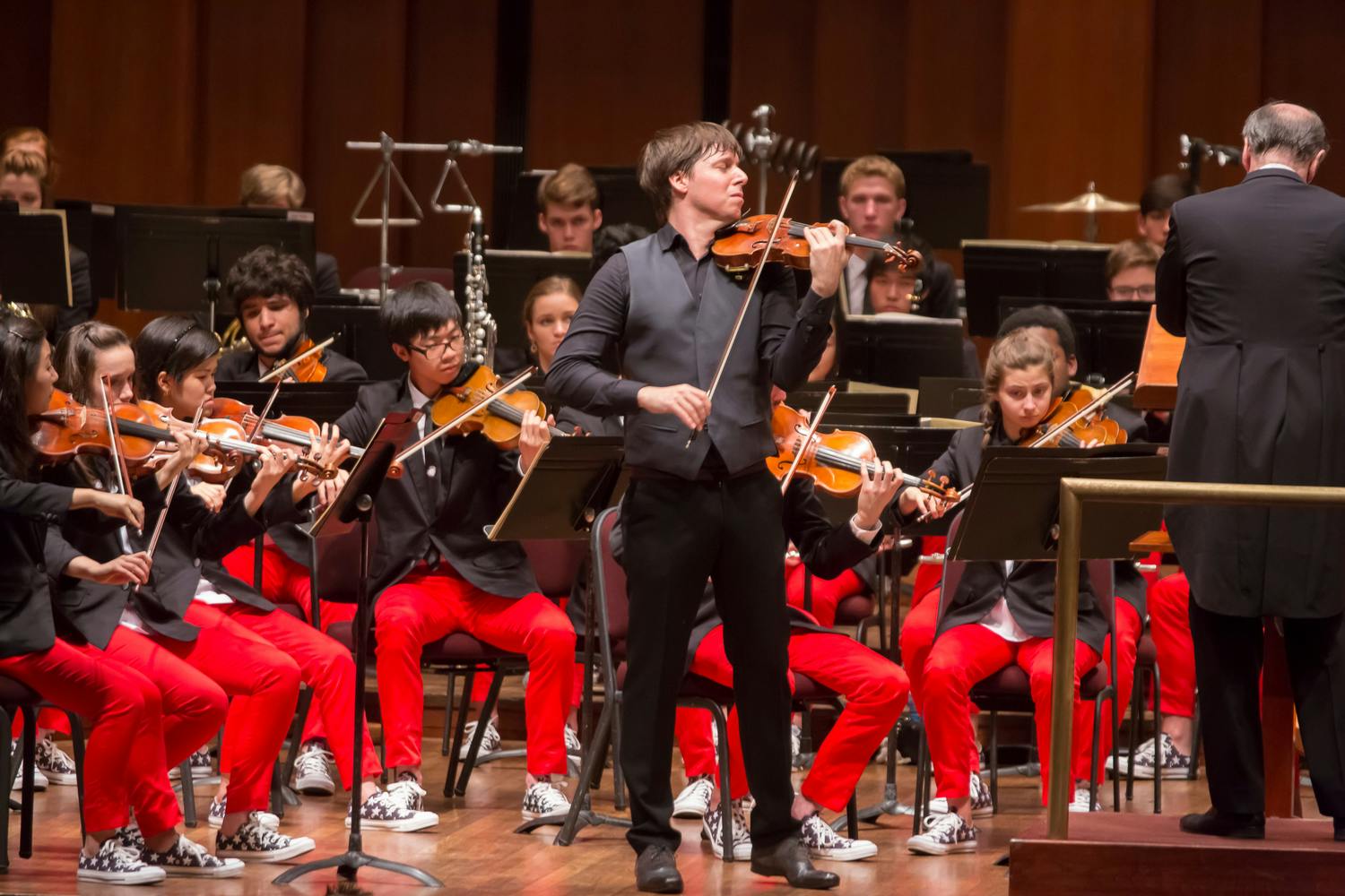 Joshua Bell performing on stage with NYO-USA musicians