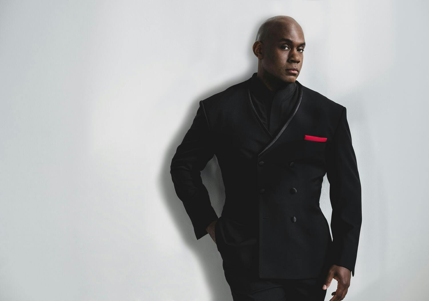 Joseph Young wearing a black suit with red pocket square