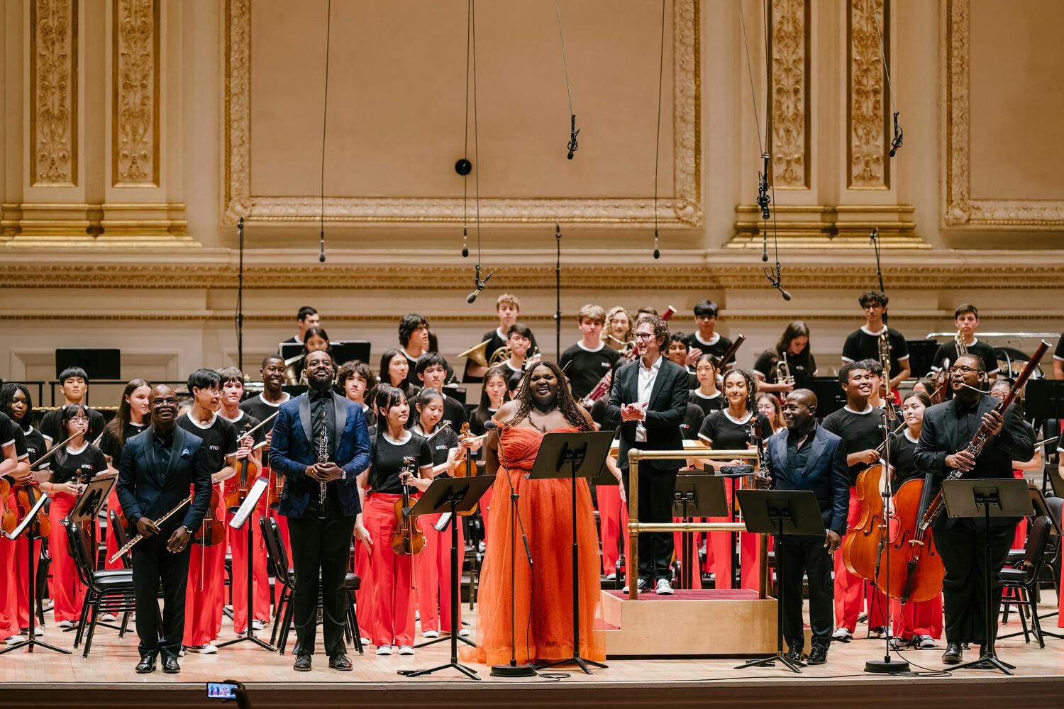 The NYO2 Orchestra and guest performers pose together on stage at Carnegie Hall
