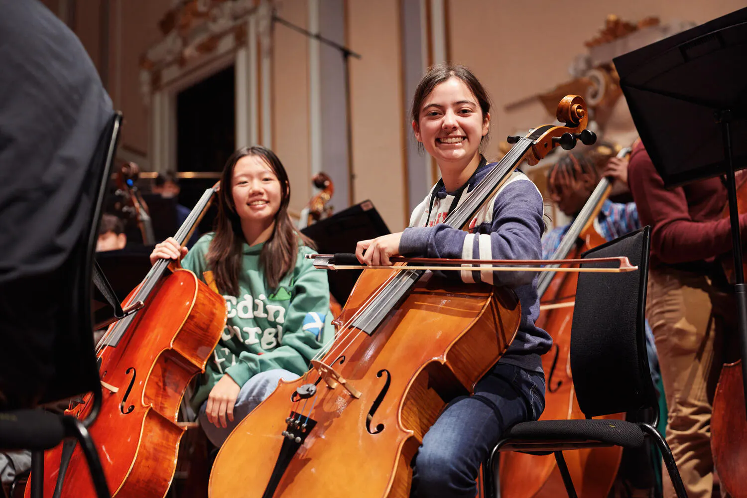 Two smiling NYO2 female cellists