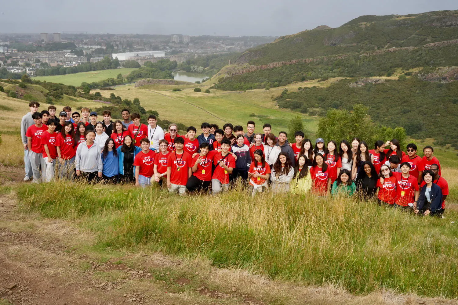 The NYO2 Orchestra pose together in the countryside of Edinburgh