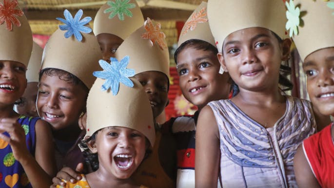 Laughing children wearing paper hats