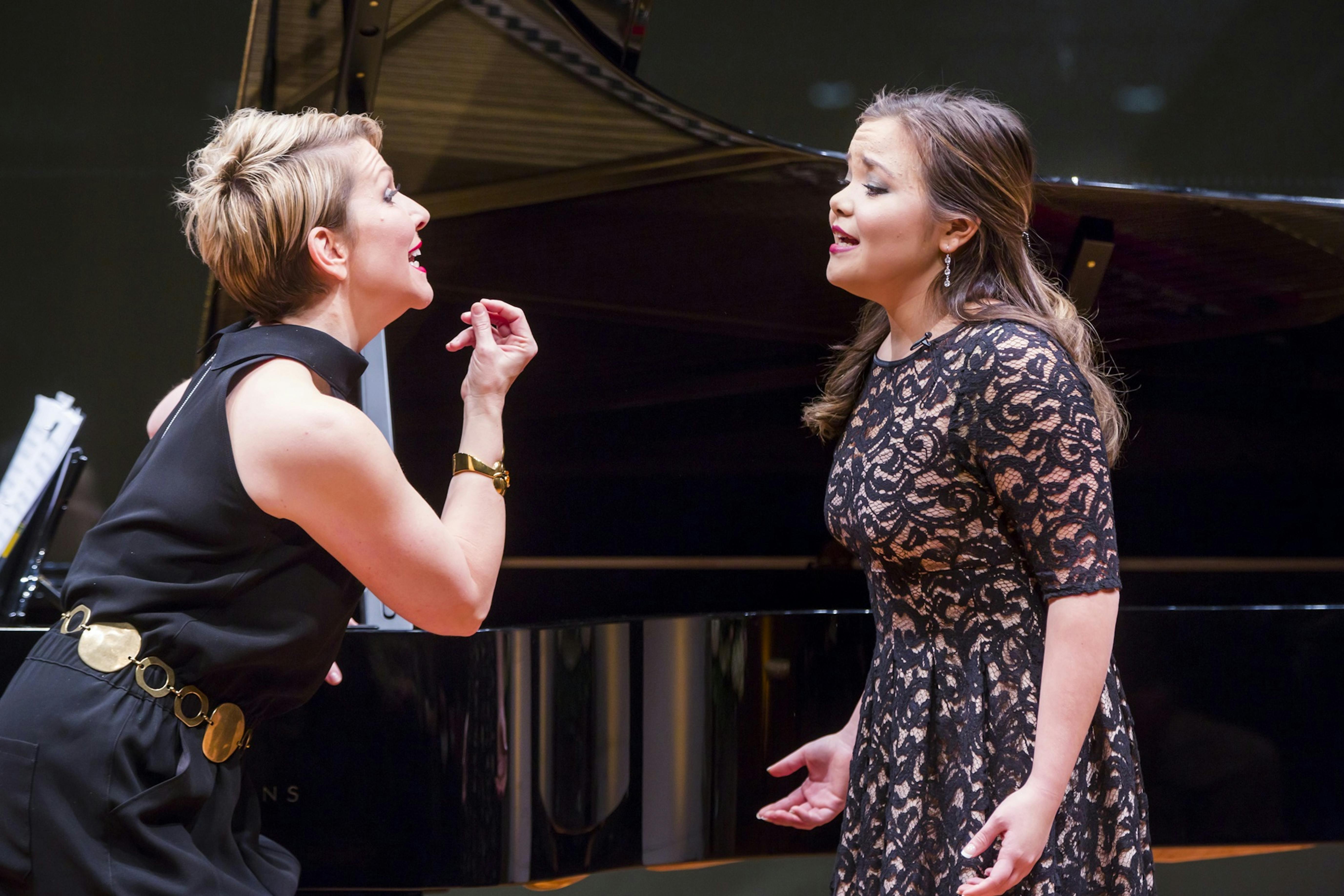 Joyce DiDonato coaches a mezzo-soprano in front of a grand piano.