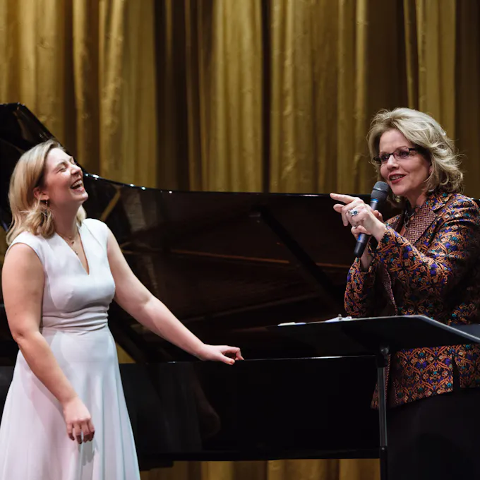 Renée Fleming coaches before a piano as a student laughs