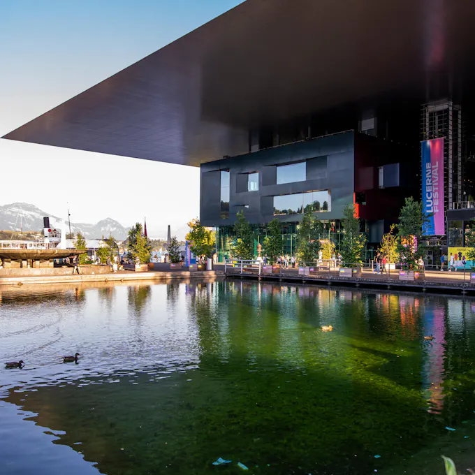 A concert hall overlooking a pool with a view of mountains in the background