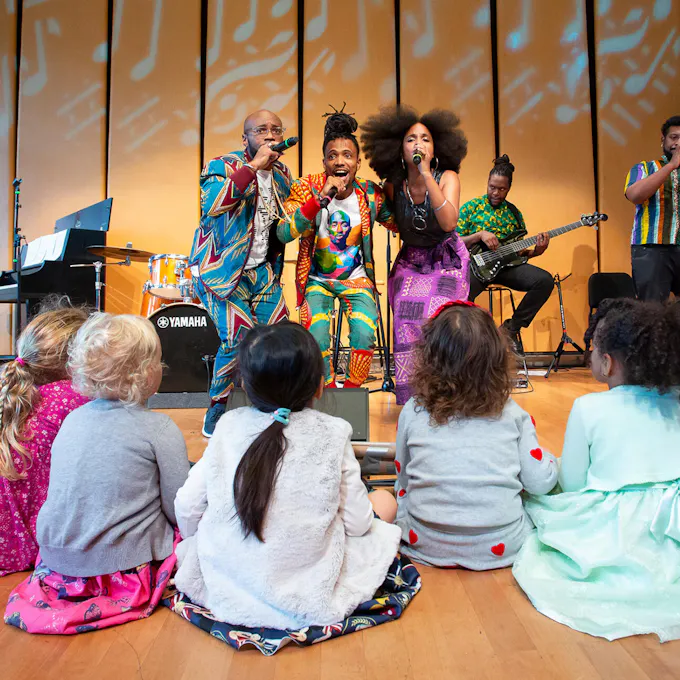 Musicians performing for a group of young children