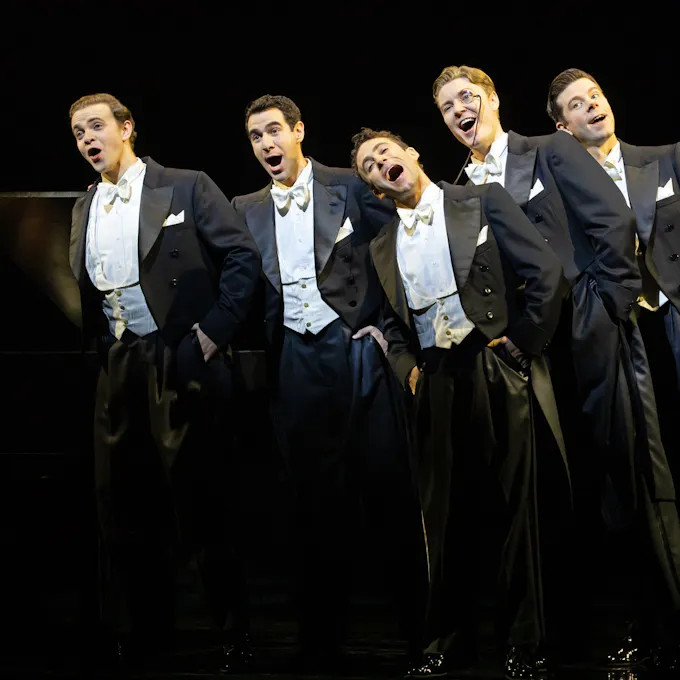 Five men in tuxedos sing