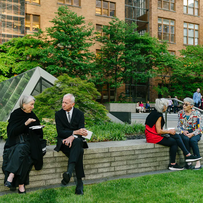 Men and women sit together in a rooftop garden