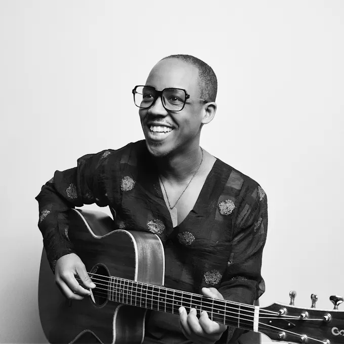 Louis Cato holding a guitar