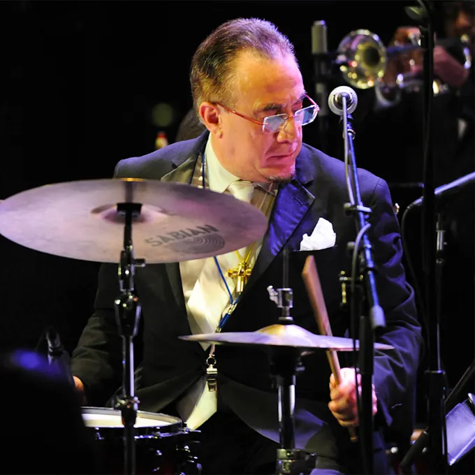 Bobby Sanabria plays drums, wearing a tuxedo