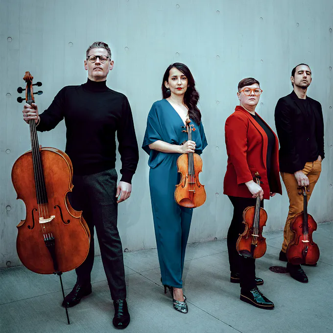 Members of the Catalyst Quartet holding string instruments