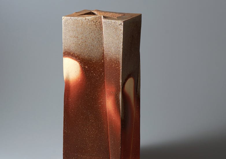 A tall rectangular pottery item in shades of brown