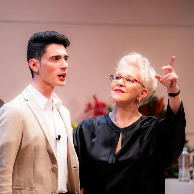 Joyce DiDonato instructs a male singer, hand outstretched