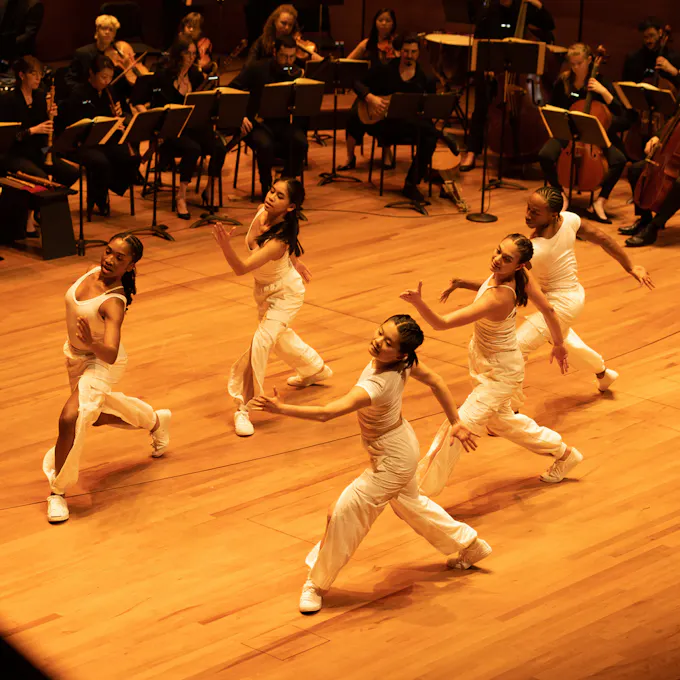 A group of dancers surrounded by musicians