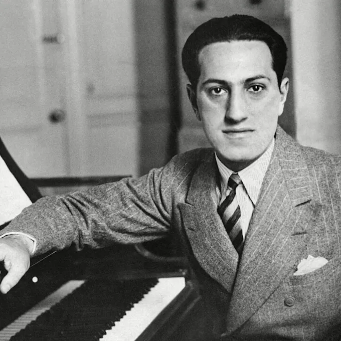 George Gershwin sitting at a piano