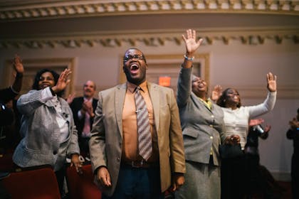 A group of people sing and dance during a performance at Carnegie Hall.