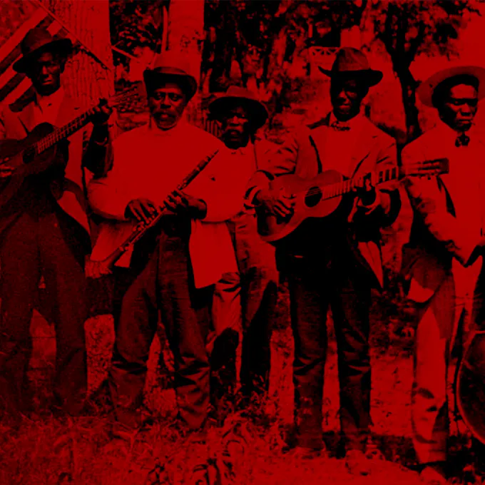 A picture in red tones of a band of African American men standing in a yard playing their instruments