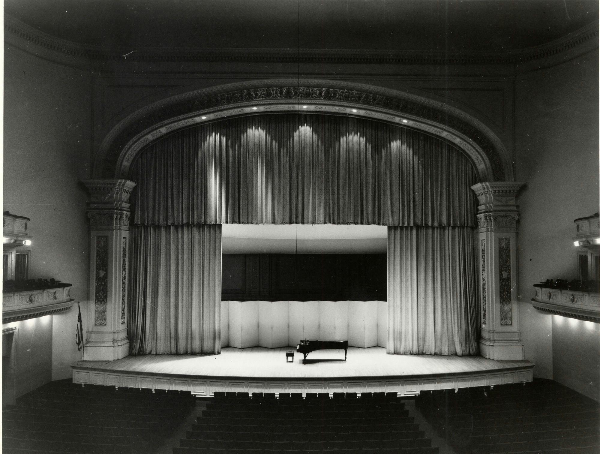 Carnegie Hall’s stage with a piano surrounded by a curtain and backdrop, 1973