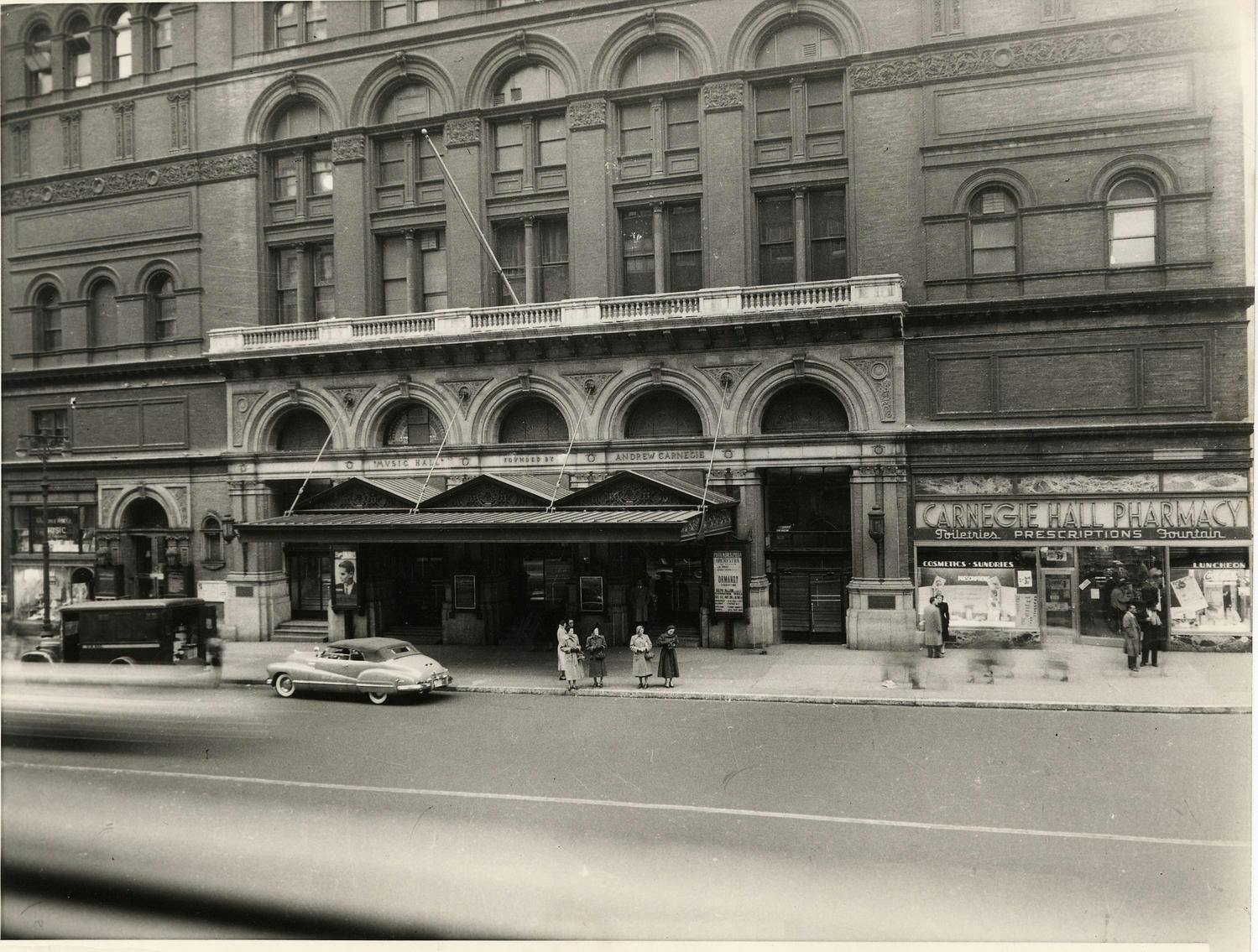 Black-and-white photo of Carnegie Hall’s 57th Street façade, 1950