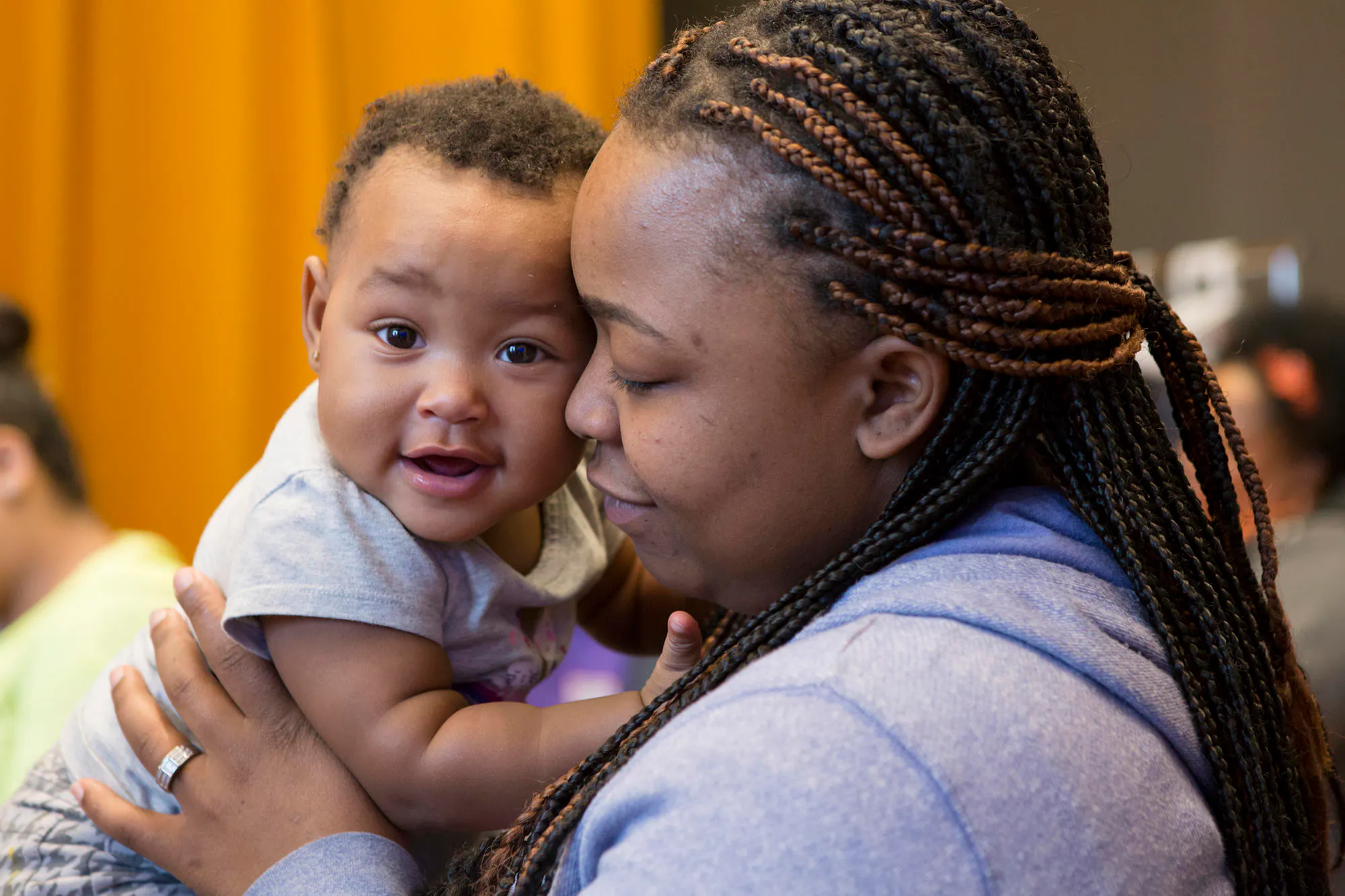Photo of a mother holding her baby close during a Lullaby Project songwriting session