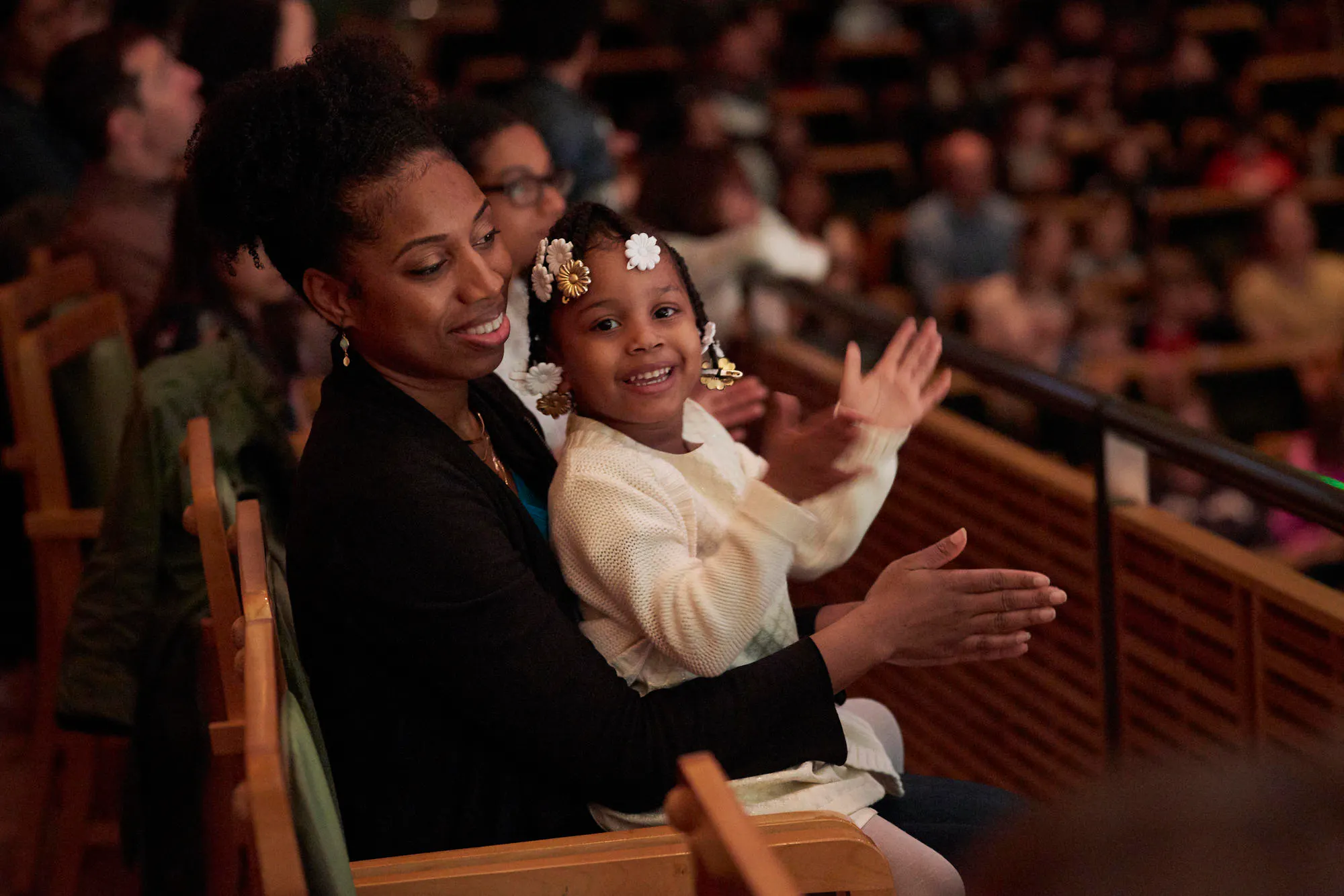 Photo of a mother and daughter clapping along to the music during a Family Concert in Zankel Hall