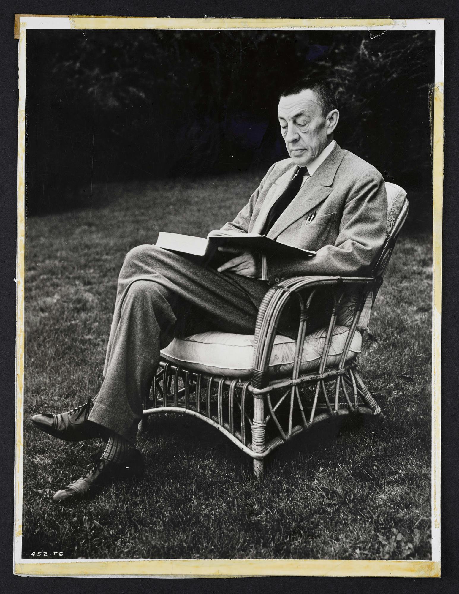 Photo of Sergei Rachmaninoff reading outdoors